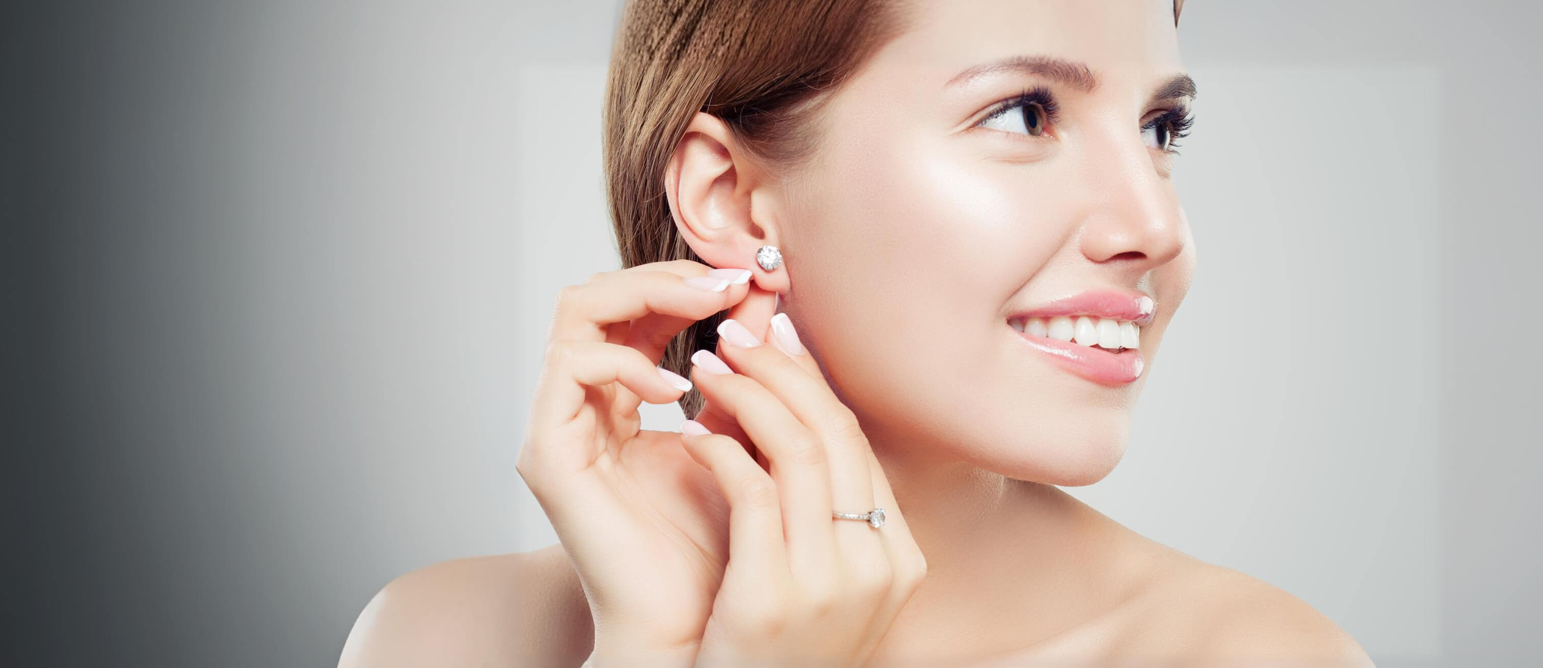 Woman putting on Moissanite Diamond earrings